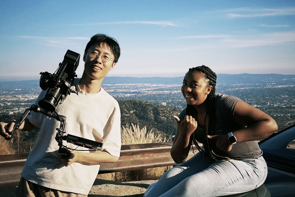 A camera operator and an actor laughing at an overlook above the city, from Erik Dylan Matibag's shoot