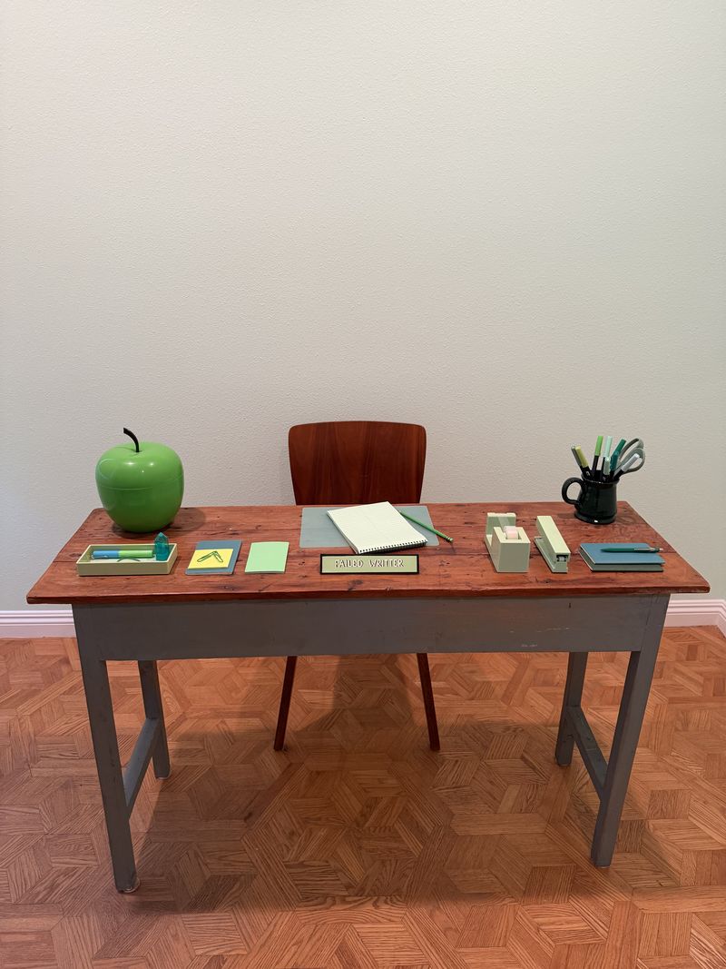 A dressed desk with a green apple, from Justin Michael's set