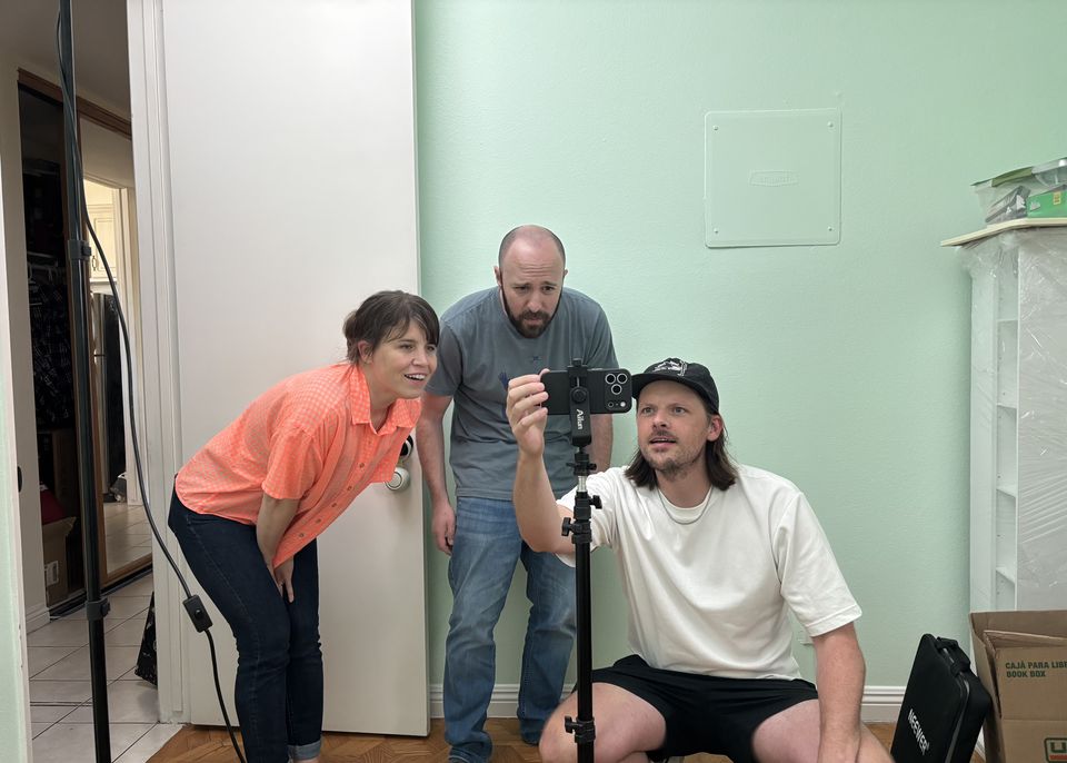 Justin Michael and collaborators crowded around a phone on a tripod
