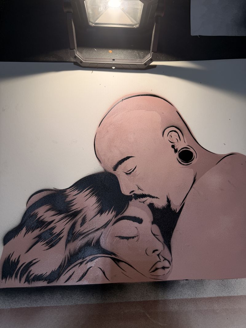 Omar Bocanegra's finished cut piece of two faces pressed together, under a work lamp